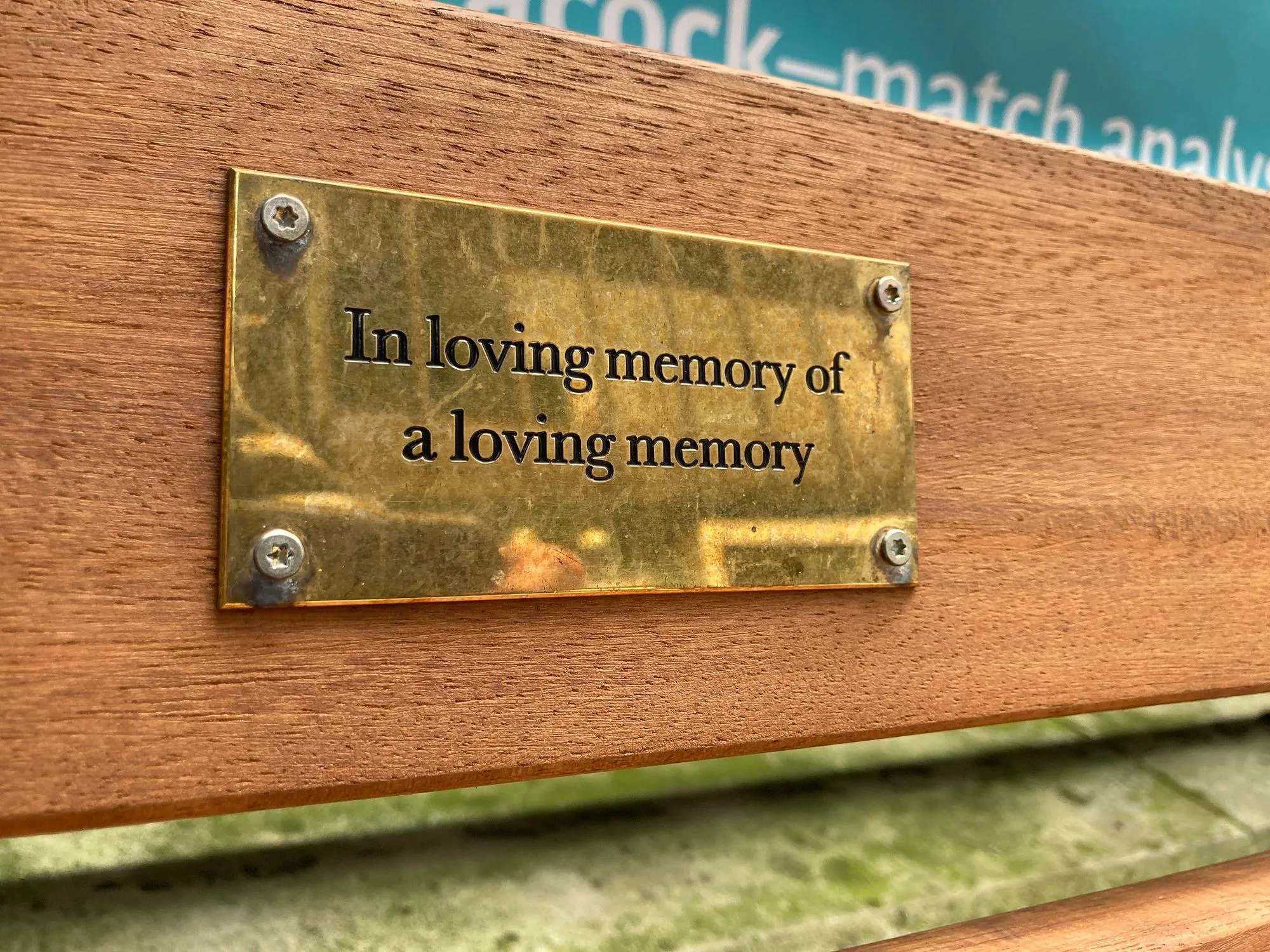 A humorous brass bench plaque in London reads "In loving memory of a loving memory".