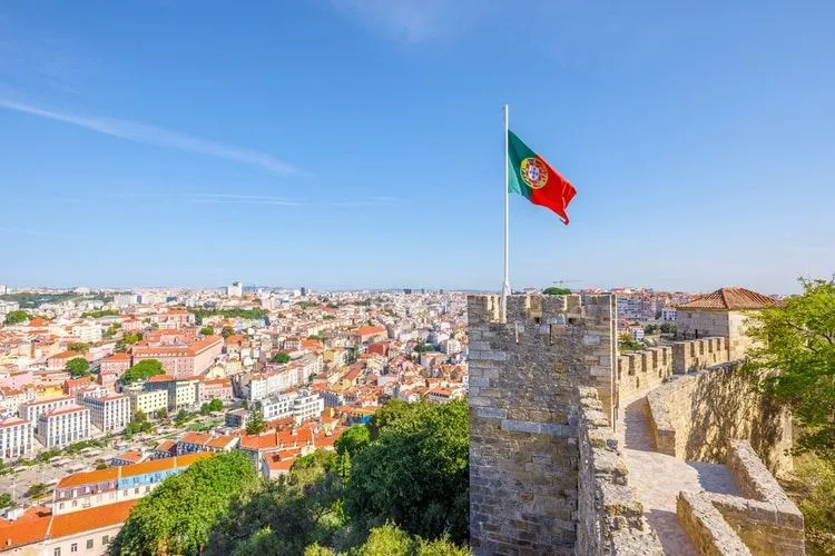 Aerial viewof Portugal with Portuguese flag waving in the sky