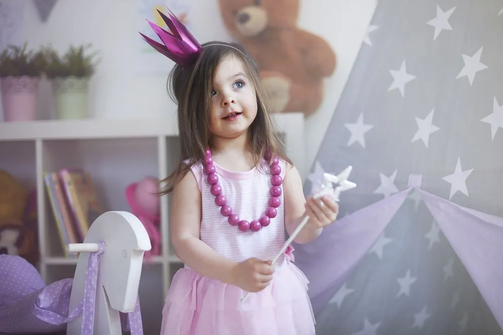 A little girl dressed as a princess with pink crown