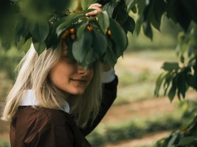 A girl hiding her face with leaves