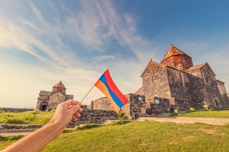 National flag of Armenia on the background of Sevanavank Monastery on the shore of Lake Sevan