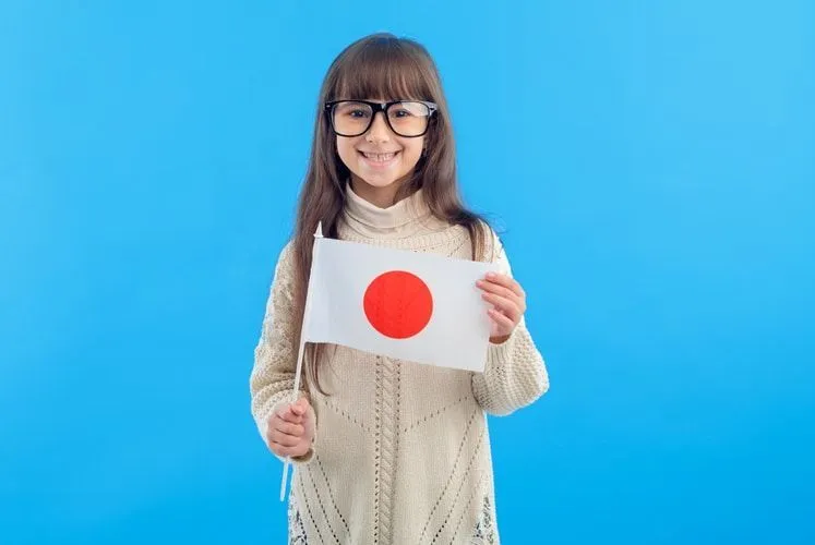 A little girl holding the flag of Japan