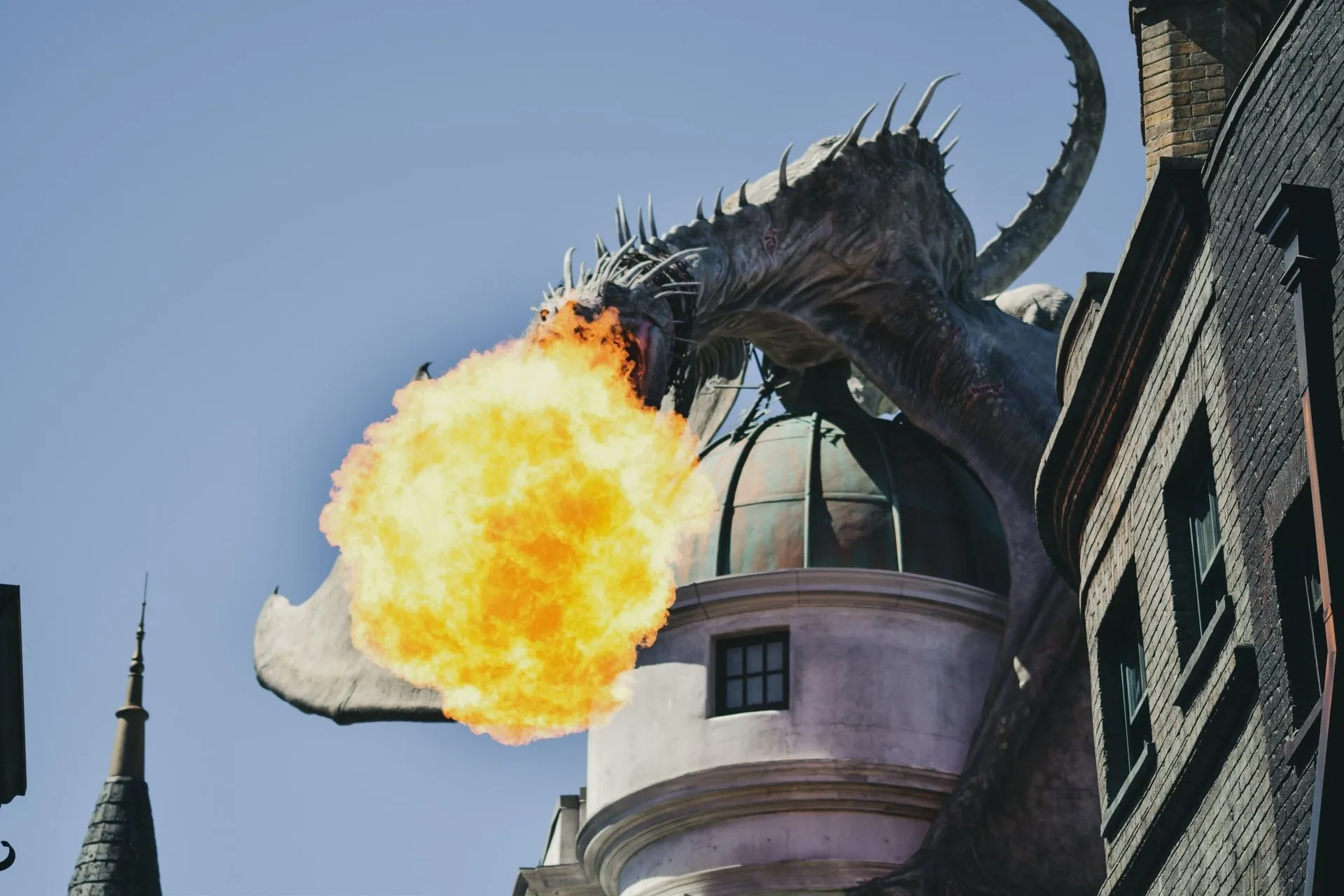 A fiery dragon expelling fire out of it's mouth sitting over a tower