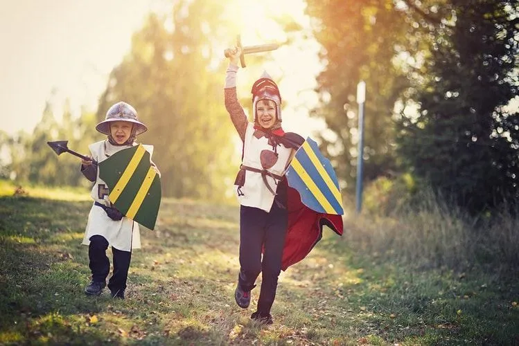 Two little boys dressed up as warriors carrying sword and shield