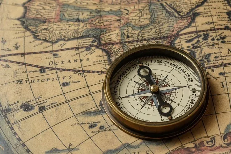 Antique compass on an old world map