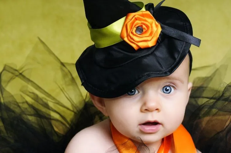 A newborn baby wearing witch hat