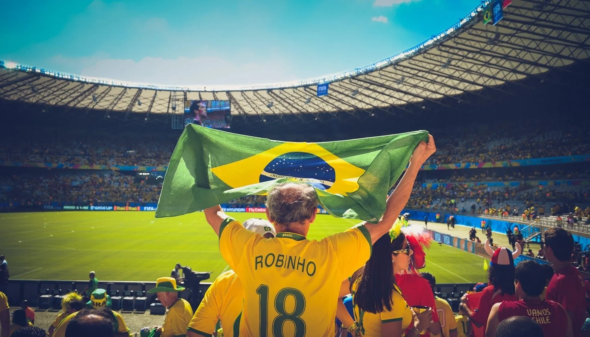 Man holding Brazilian flag in football stadium