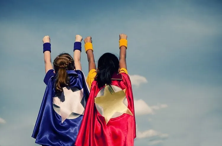 Two girls dressed and posing as superheroes
