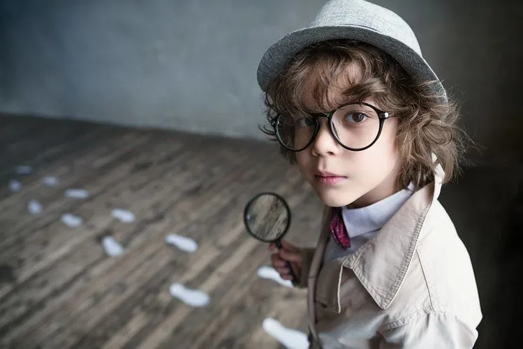A little boy dressed as a detective in Victorian fashion