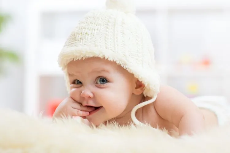 Close up of newborn baby wearing white knitted hat