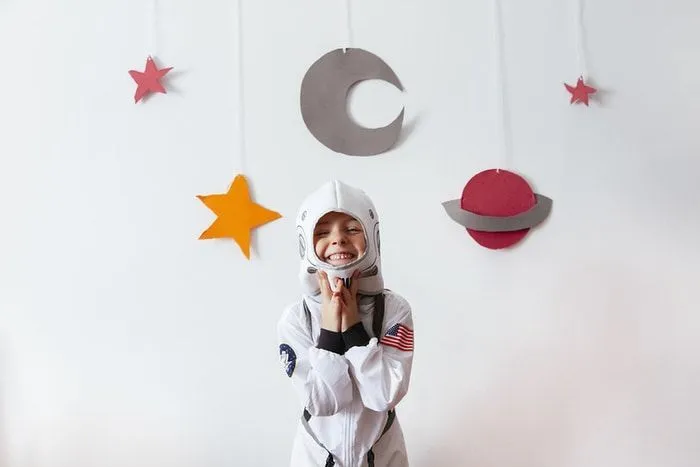 little girl with an astronaut costume at home