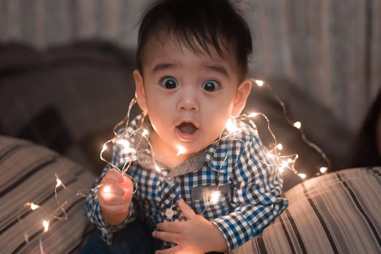 A baby boy wrapped in fairy lights
