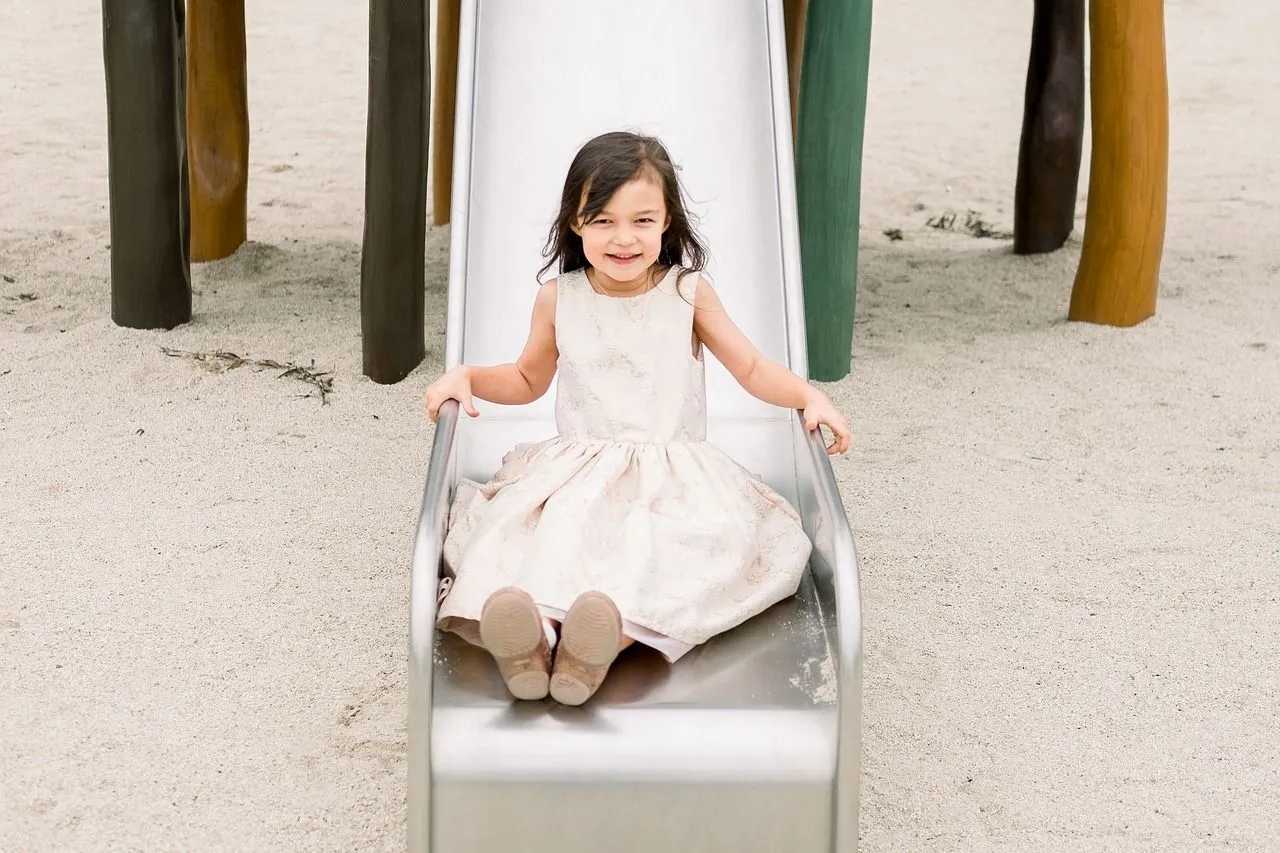 A little girl playing on a slide in playground