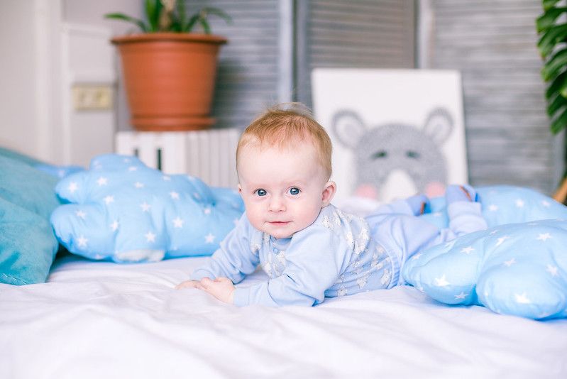 Cute little boy crawling on bed surrounded by blue pillows - Nicknames