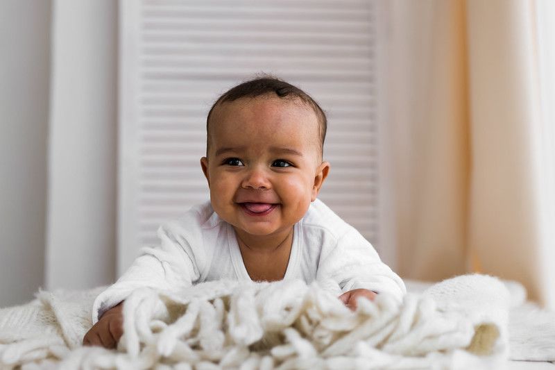 Cute little baby playing with white knitted blanket - Nicknames