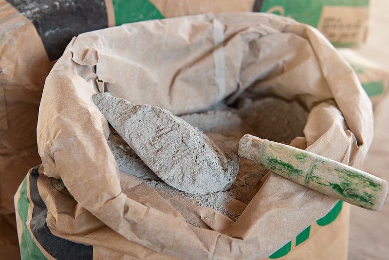 Cement mortar with a trowel placed on a cement bag.