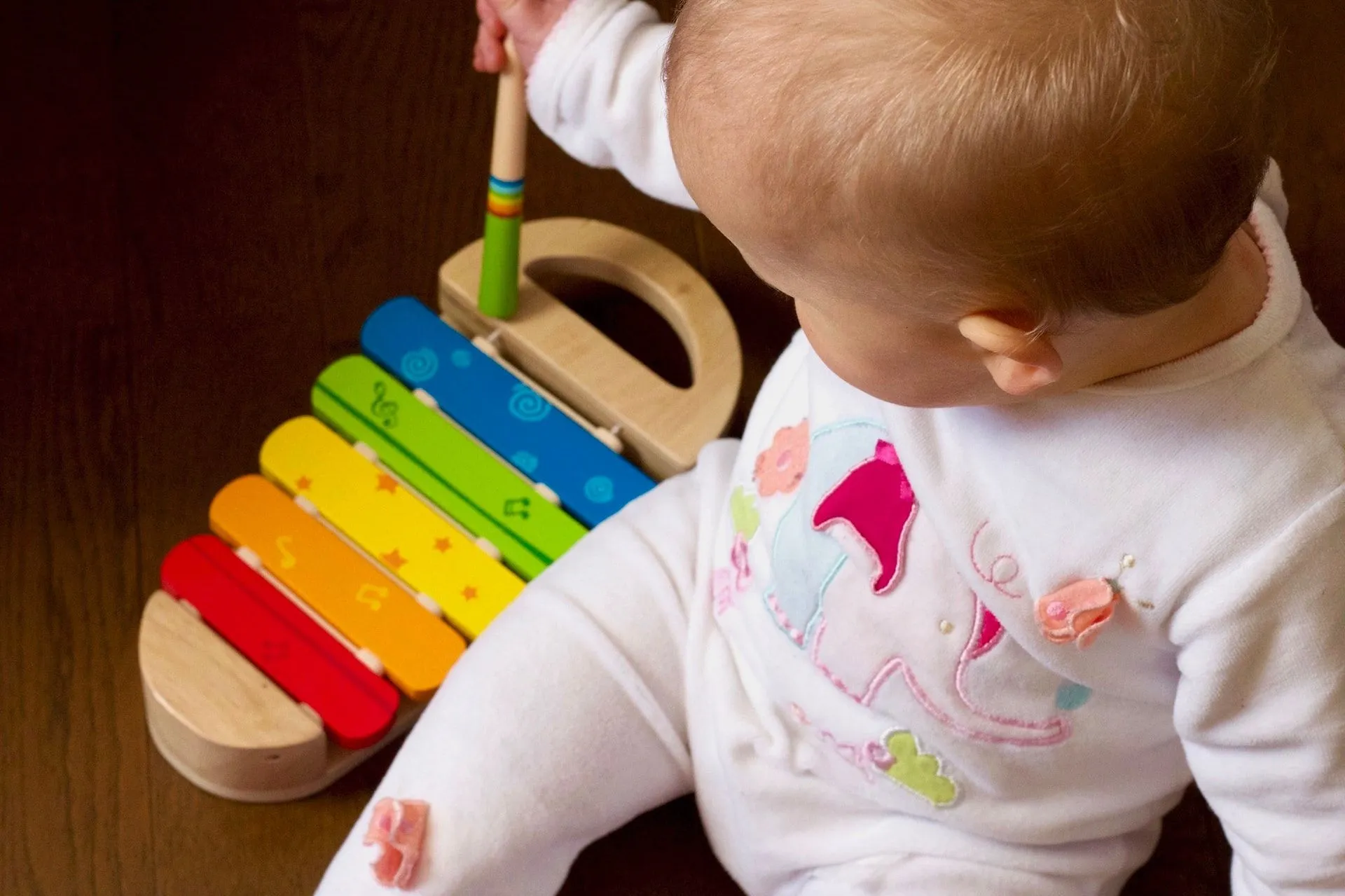 A newborn baby playing with xylophone
