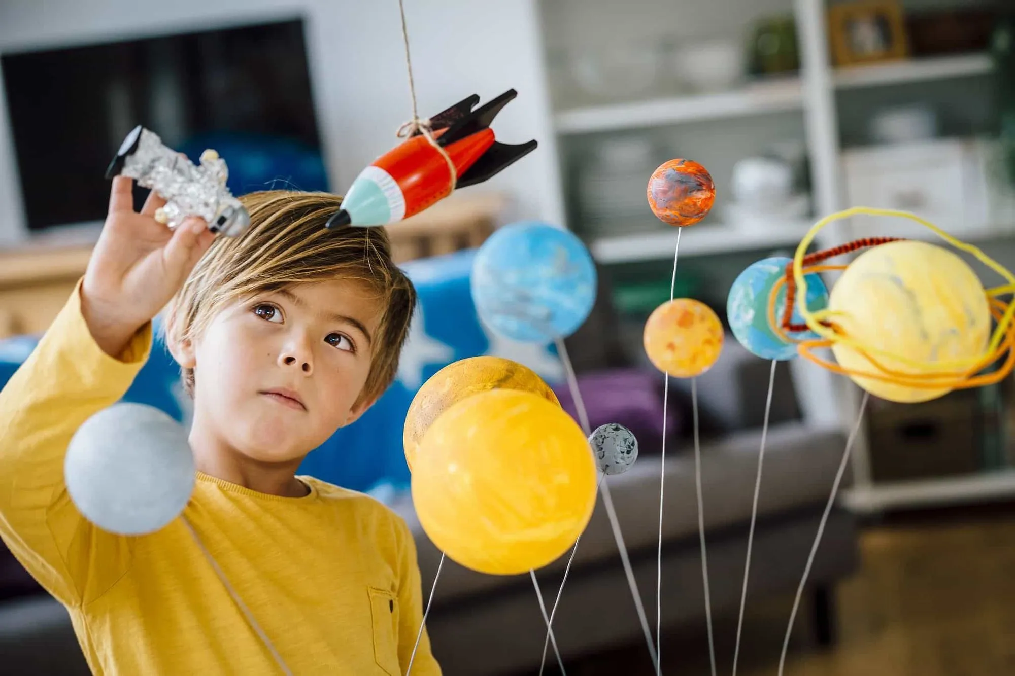 Boy playing with solar system project.