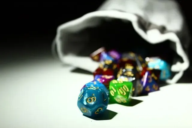 Colorful d20 dice scattered outside the pouch