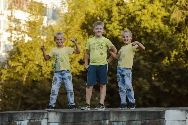 Three Russian kids standing on a wall wearing matching tshirts