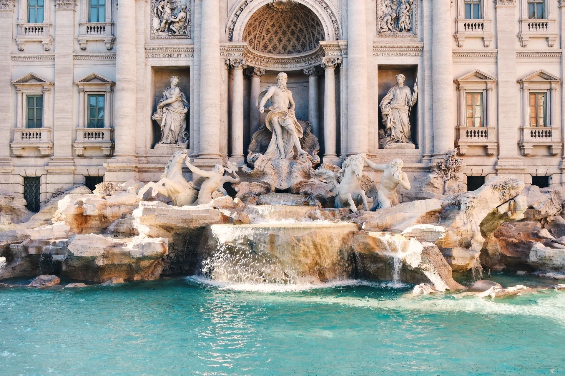 Water fountain in front of intricate roman statues