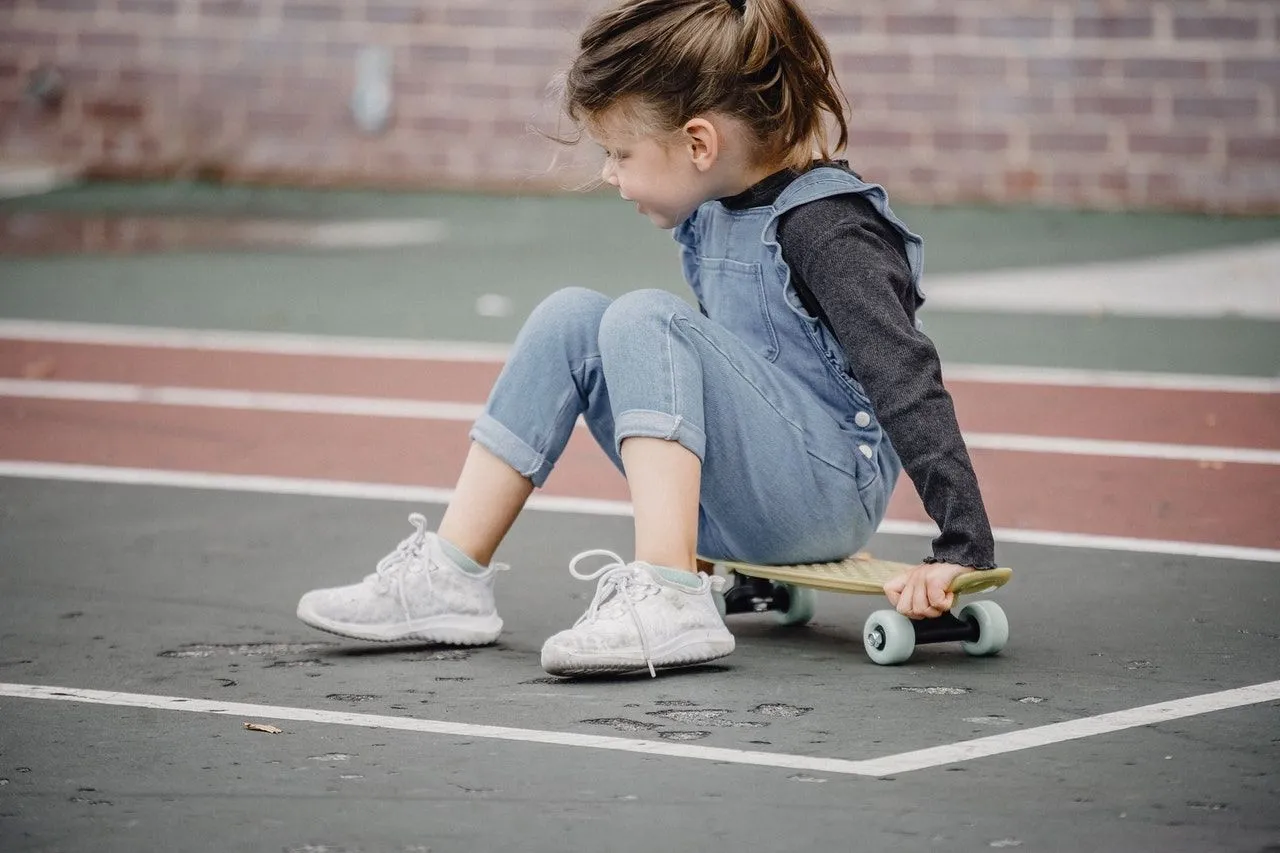 A little girl learning how to ride a skateboard