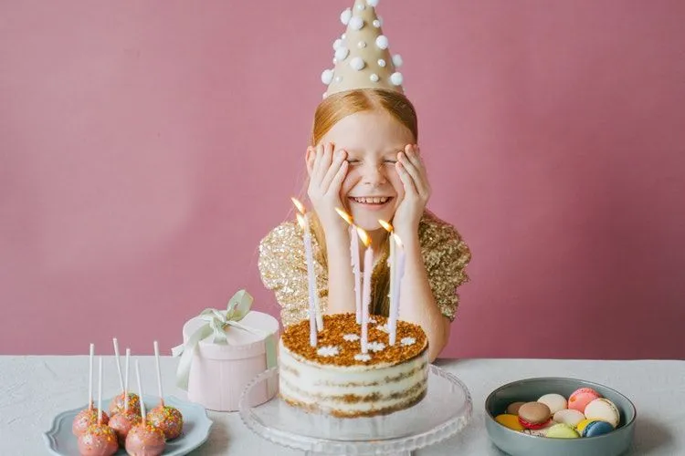 A girl making a wish on her birthday cake