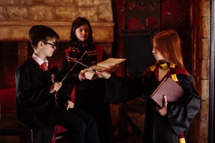 Kids dressed as characters from Harry Potter practicing with wands