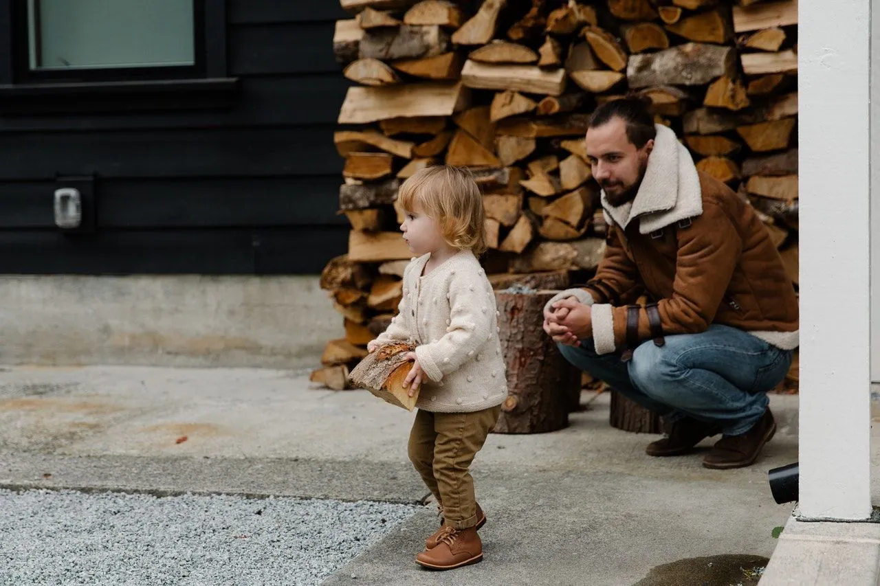 A little girl walking with a piece of log