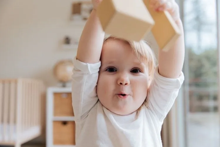 A baby boy playing with wooden toy