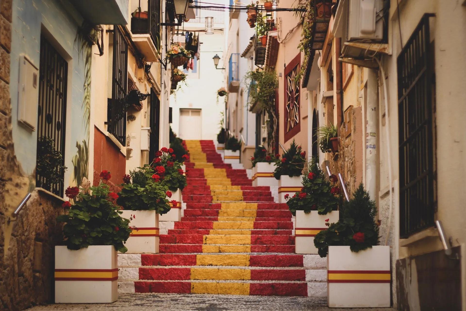 A red,yellow painted stairs in an alley in Spain