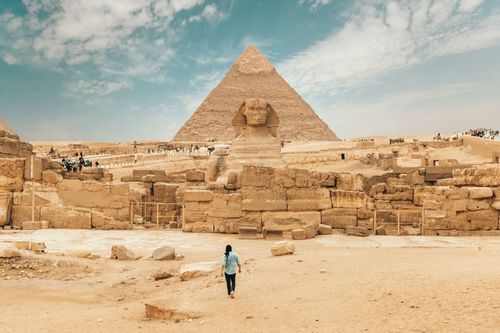 Tourist walking towards the Pyramid of Giza and the SPhinx in Egypt