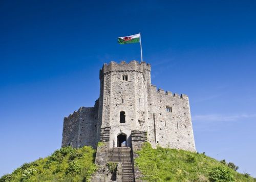 Flag of Wales waving above the Cardiff Castle situated in Parklands