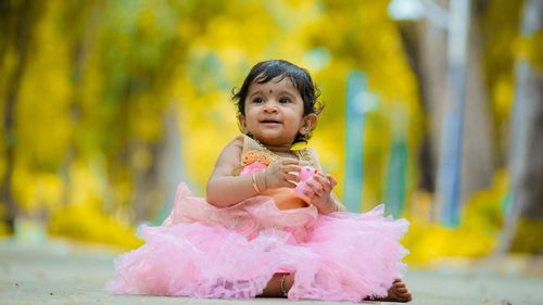 An Indian little girl wearing pink tulle dress sitting