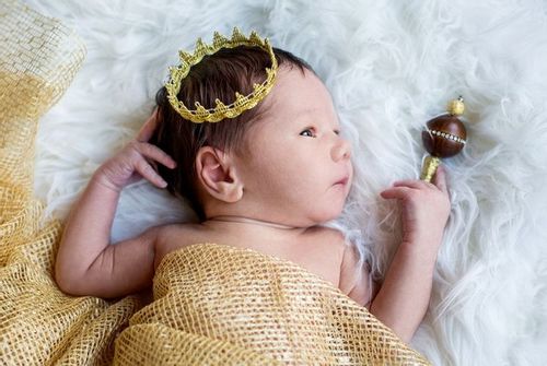 A newborn baby boy with a golden crown