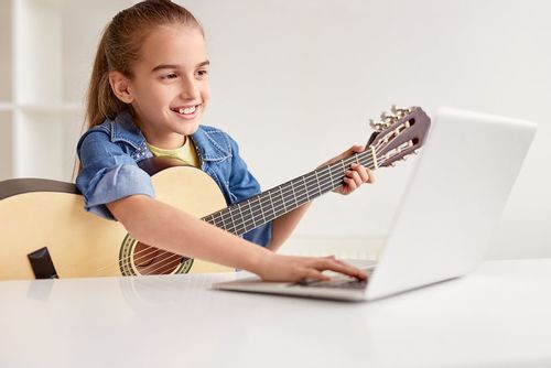 Child learning the guitar.