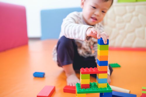 Toddler playing with building blocks.