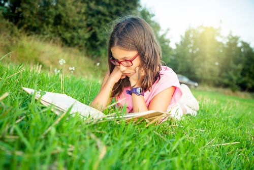 Young girl reading her new favourite poem in the garden.