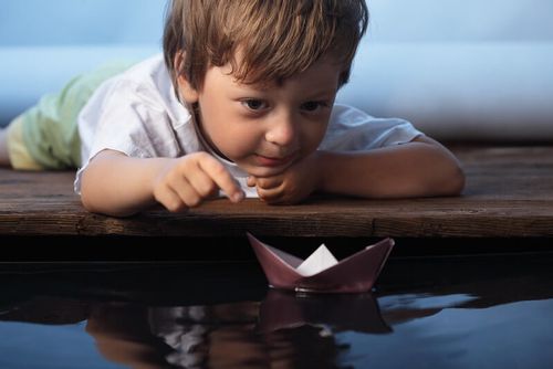 Child testing out their boat made from aluminium foil