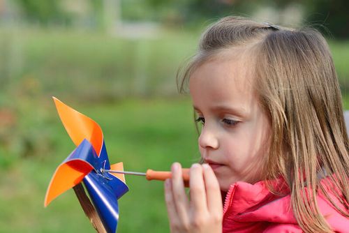Young girl making her own mini windmill.