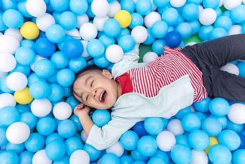 Child surrounded by glow in the dark bouncy balls you can make at home