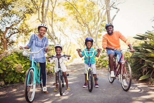 Family smiling as they ride their bikes.
