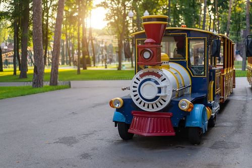 Colourful electric train in park.