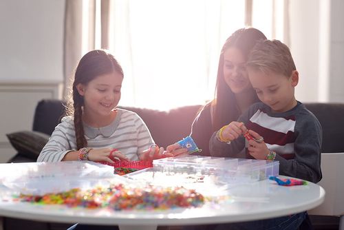 Mother and Two Children Playing With Loom Bands 