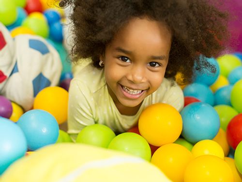 Child in a ball pit at a soft play centre.