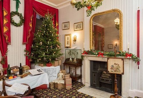 A Victorian style living room with Christmas decorations adorning the room.