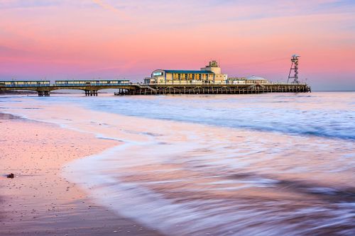 Bournemouth pier at sunset, the skies pink and lilac in the background.