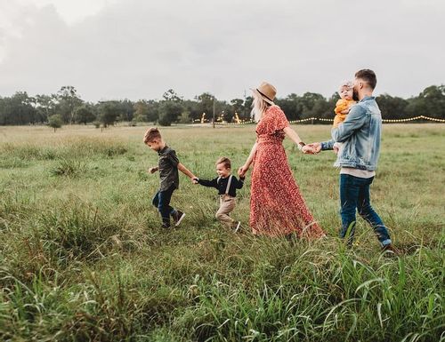 Family of five on a nature walk through the field.