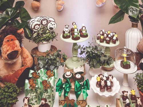 A whole table of jungle-themed cakes and sweet treats.
