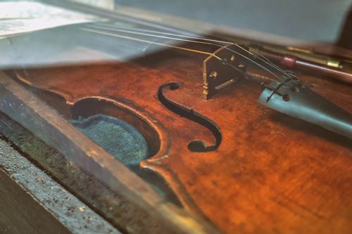 Close up of a violin from Tudor times in a display cabinet.